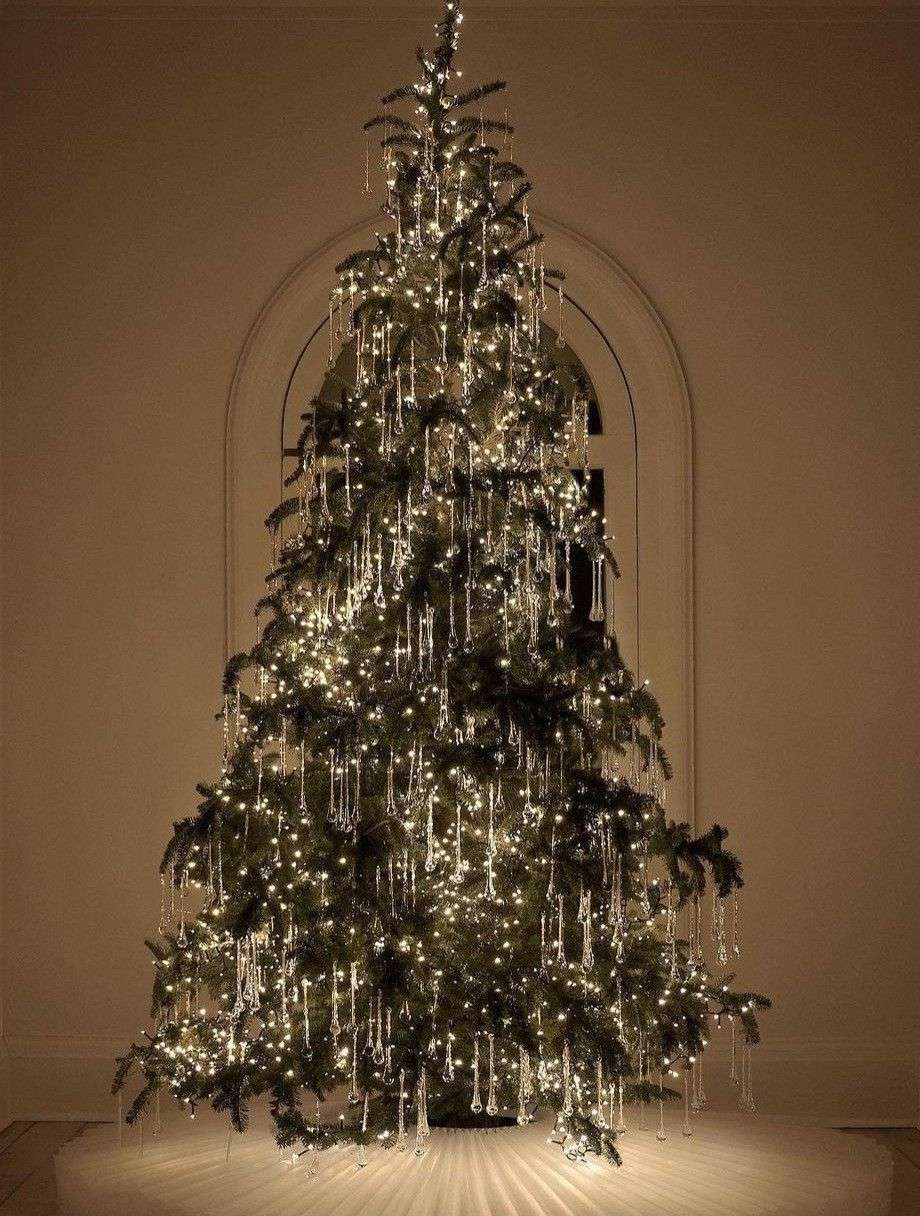 Grand sapin illuminé dans un salon